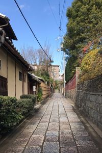 Footpath amidst buildings against sky