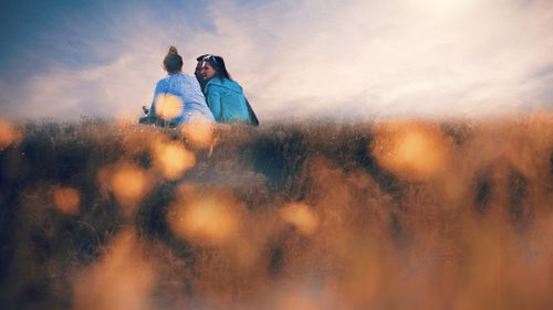 Couple kissing against sky during sunset