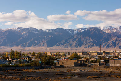 Scenic view of townscape and mountains against sky