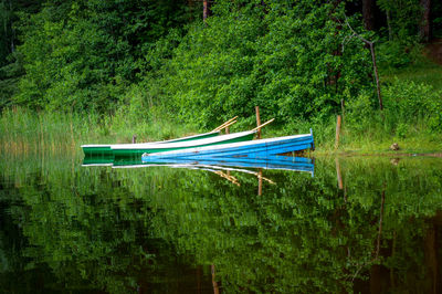 Boat moored on lake against trees