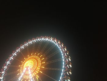 Low angle view of illuminated ferris wheel at night