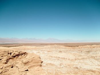 Scenic view of desert against clear blue sky