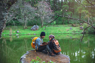 Man sitting by the lake in forest