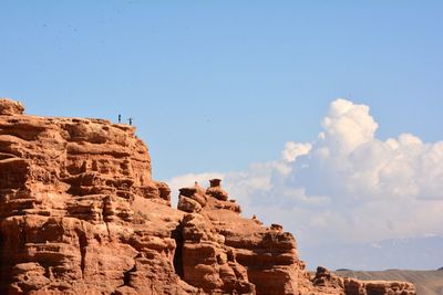Low angle view of rocks against blue sky