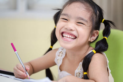 Close-up portrait of smiling girl sitting in classroom