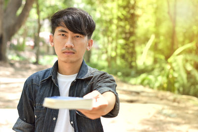 Portrait of young man standing in forest