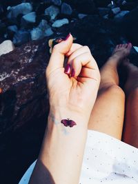 Cropped image of woman showing butterfly tattoo