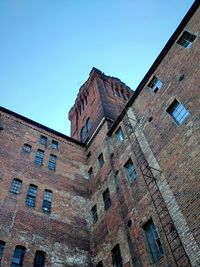 Low angle view of old building against clear blue sky