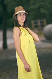 Portrait of young woman wearing hat standing outdoors