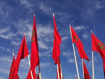 Low angle view of moroccan flags against sky