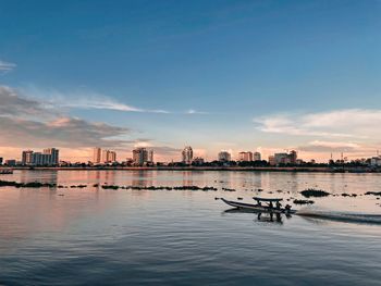 Scenic view of river by buildings against sky