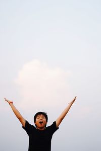 Low angle view of boy against sky
