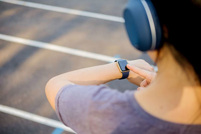 High angle view of woman checking time at sports track