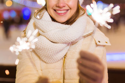 Portrait of young woman holding christmas tree