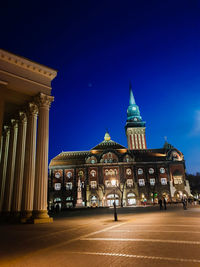 Low angle view of illuminated building against blue sky