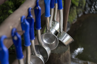 Close-up of blue kitchen utensils hanging outdoors