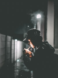 Side view of men looking away while standing in darkroom, smooking, smook, cigarette 