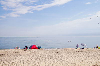 People at beach against sky