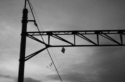 Low angle view of silhouette crane against sky