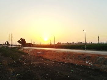 Road in city against clear sky during sunset