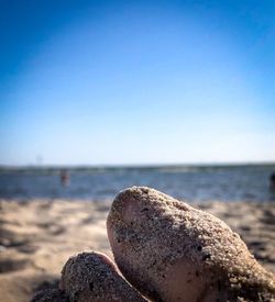 Close-up of pebbles on beach against clear sky