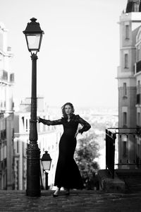 Portrait of young woman standing against clear sky in paris