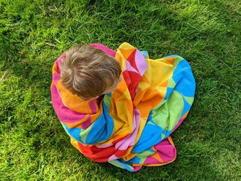 High angle view of boy sitting on grass
