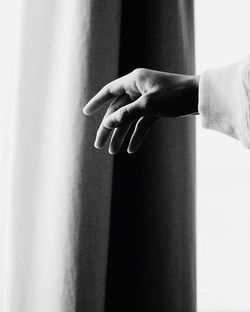 Close-up of human hand against curtain