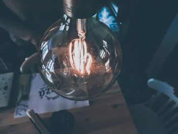 Close-up of illuminated light bulb on table