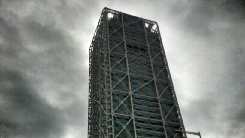 low angle view, sky, built structure, metal, cloud - sky, architecture, cloudy, tall - high, metallic, tower, cloud, overcast, dusk, no people, weather, outdoors, connection, day, grid, silhouette