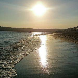 Sun shining through clouds over river