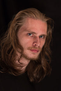 Close-up portrait of serious man on black background