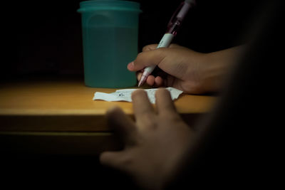 Midsection of woman holding paper at home