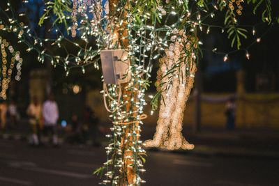 Illuminated christmas tree on street at night