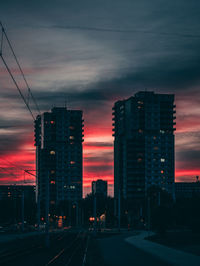 Illuminated buildings against sky at sunset