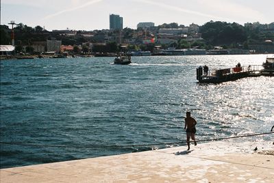 Rear view of men looking at sea against sky