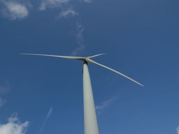 Low angle view of wind turbines against sky