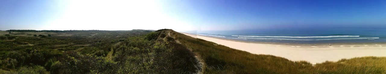 Panoramic view of beach against clear blue sky