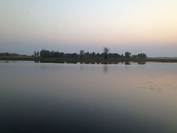 Scenic view of lake against clear sky during sunset