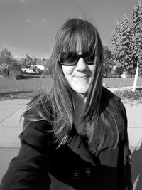 Portrait of young woman wearing sunglasses standing outdoors