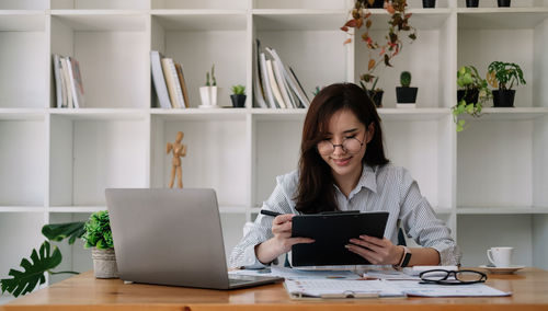 Young woman using laptop at table