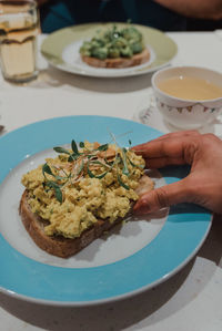 Close-up of hand holding food served in plate