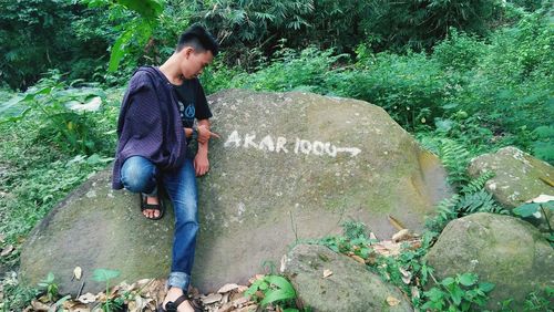 Side view of man holding rock