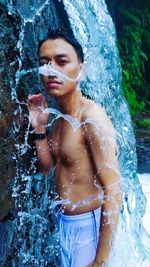 Portrait of shirtless man standing in water