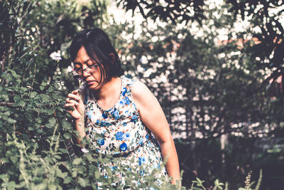 Woman standing against plants
