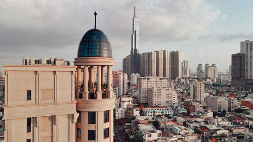 Modern buildings in city against cloudy sky