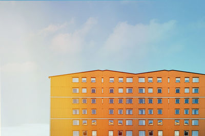 Low angle view of yellow building against sky