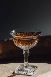 Whiskey cocktail in vintage hobnail glass atop wooden barrel