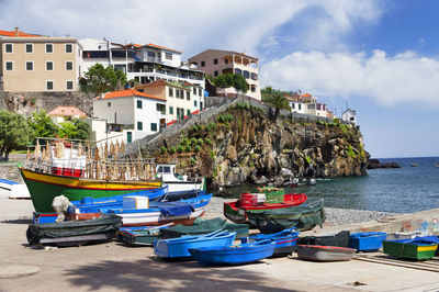 Boats on shore against built structures