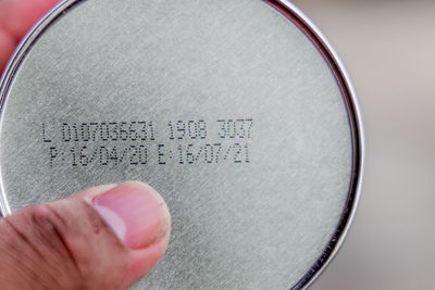 Close-up of hand holding paper with text